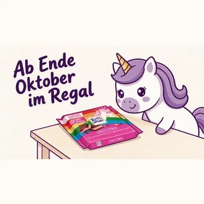 Die pinke Ritter-Sport-Unicorn-Tafel liegt auf einem gezeichneten Holztisch, Yumi schaut von rechts darauf. Über der Szene steht der handgeletterte Schriftzug „Ab Ende Oktober im Regal“.